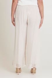 Model Chanel wearing the Silk Pant in colour Ivory, from the back