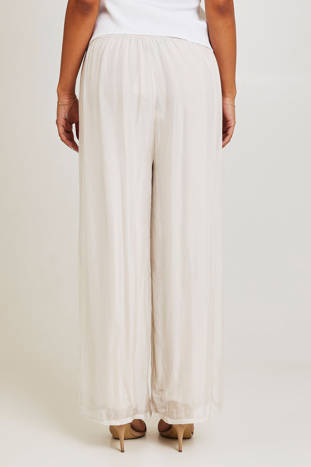 Model Ziara wearing the Silk Pant in colour Ivory, from the back
