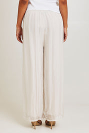 Model Ziara wearing the Silk Pant in colour Ivory, from the back