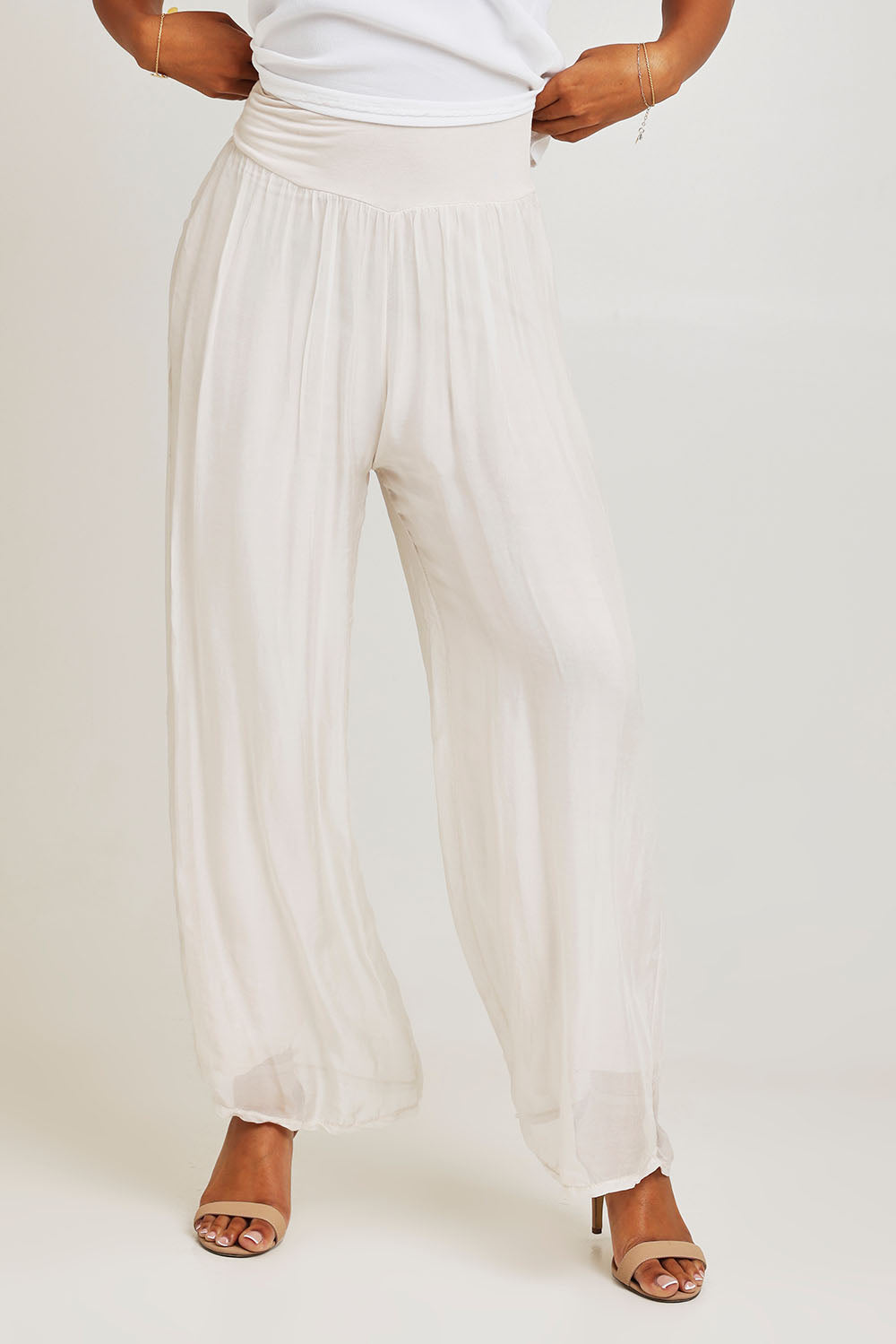 Model Ziara wearing the Silk Pant in colour Ivory, from the front, cropped image