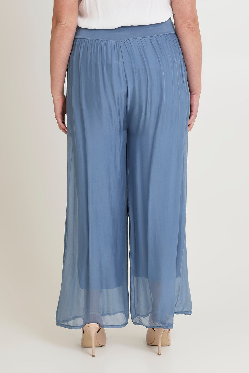 Model Chanel wearing the Silk Pant in colour Jeans (Blue), from the back