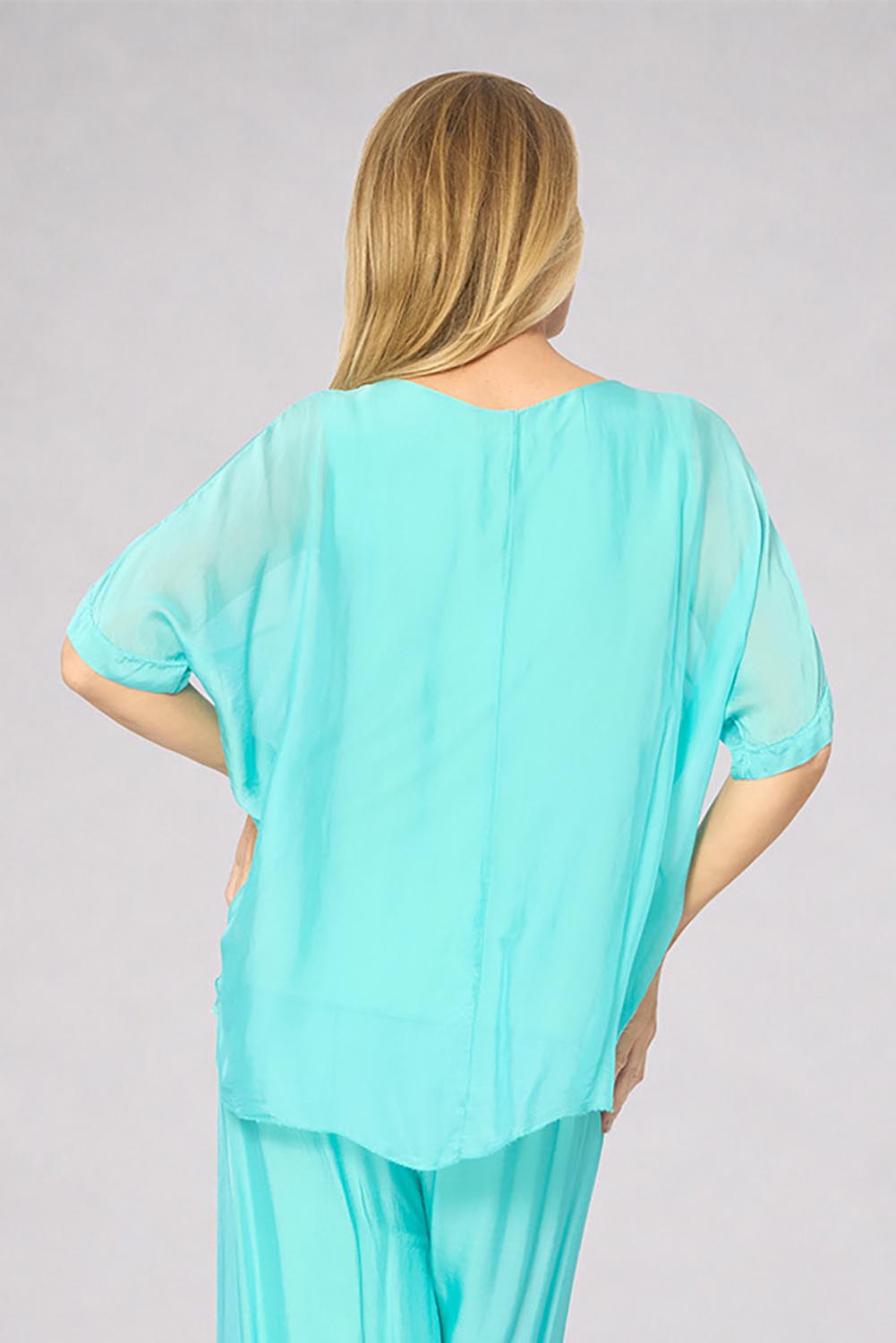 Model Genericm wearing size sample of the Silk Blend Three Layer Raw Edge Top - Acqua in colour Acqua, from the back
