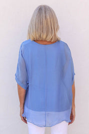 Model Sandy wearing the Silk Blend Three Layer Raw Edge Top in colour Blueturco (Blue), from the back