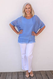 Model Sandy wearing the Silk Blend Three Layer Raw Edge Top in colour Blueturco (Blue), from the front, showing the whole outfit