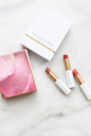 A model wearing the Lip Nourish Trio in colour Nudes, from the front, showing the whole outfit