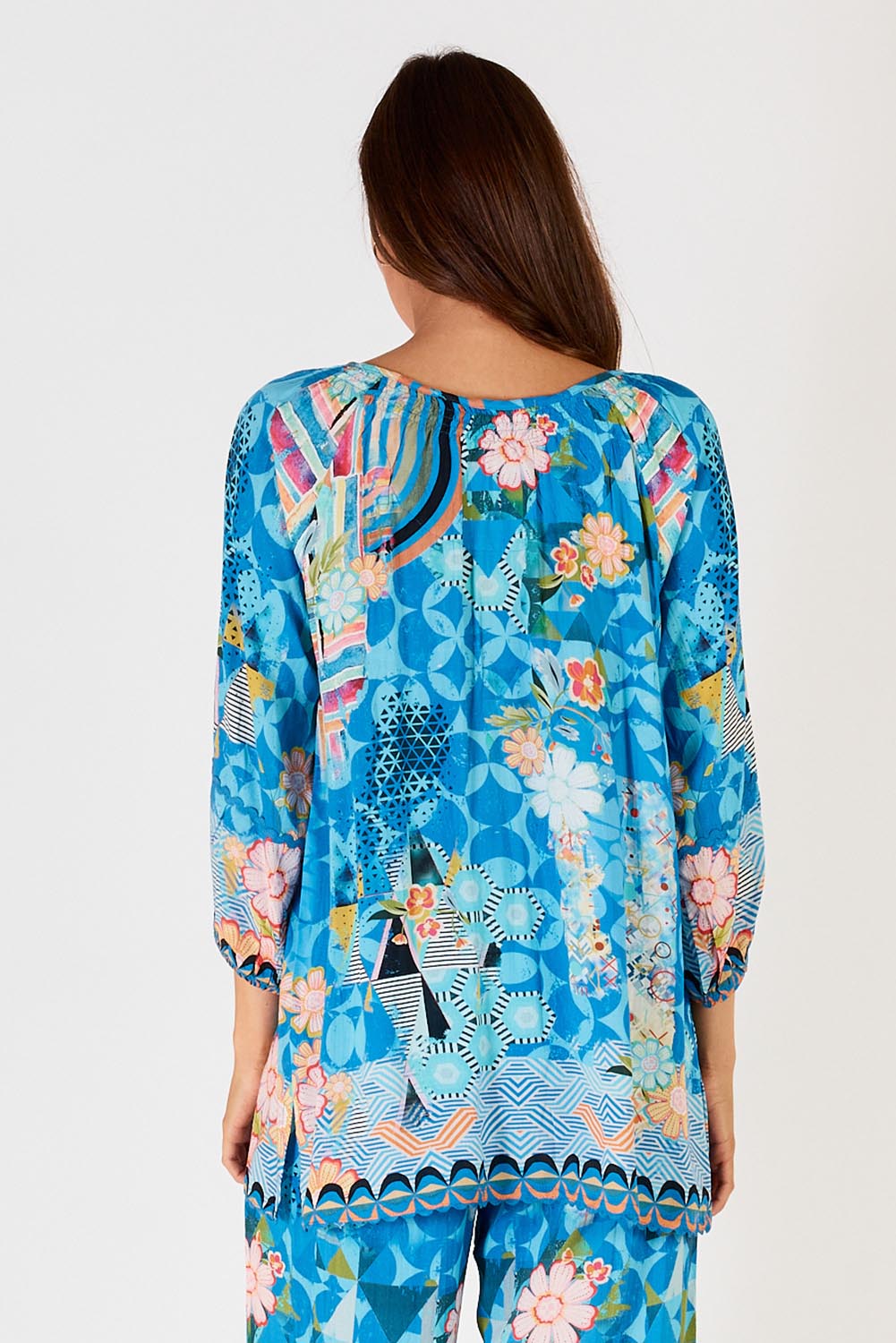 A model wearing the Amalfi Top in colour Blue (Blue), from the back