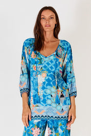 A model wearing the Amalfi Top in colour Blue (Blue), from the front, cropped image