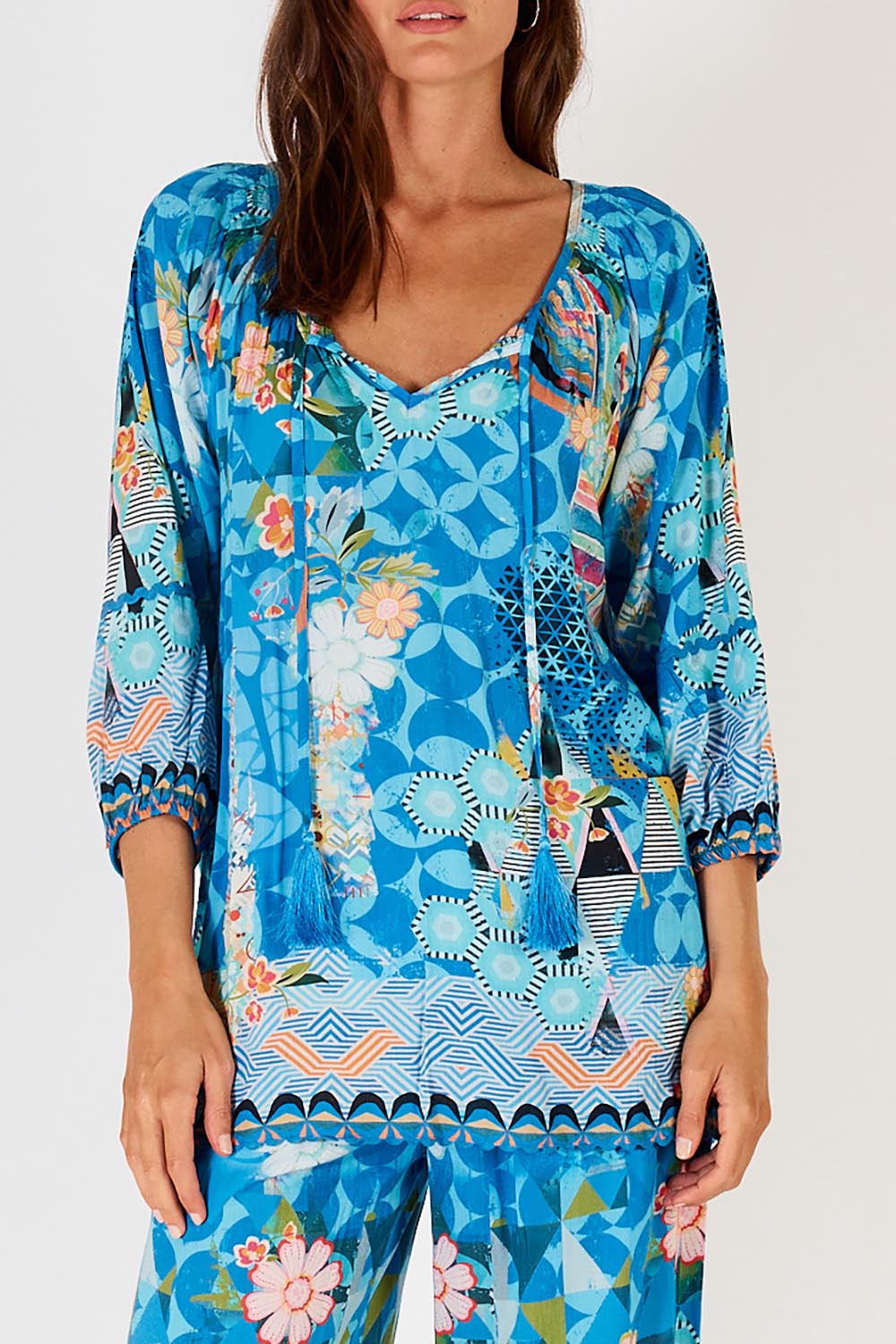 A model wearing the Amalfi Top in colour Blue (Blue), from the front, cropped image