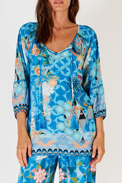 A model wearing the Amalfi Top in colour Blue (Blue), from the front, cropped image