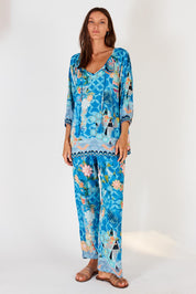 A model wearing the Amalfi Top in colour Blue (Blue), from the front, showing the whole outfit
