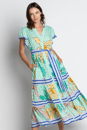 A model wearing the Aquila Maxi Dress in colour Mist (Green), from the front, cropped image