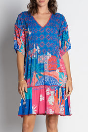 A model wearing the Busena Dress in colour Ocean, from the front, cropped image