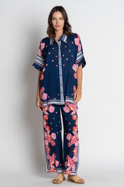 A model wearing the Ladera Pant in colour Navy (Blue), from the front, showing the whole outfit