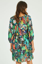 Model Madeline wearing size S of the Lucile Tiered Dress in colour Midnight (Black), from the back