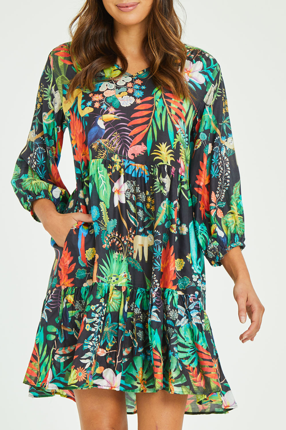 Model Madeline wearing size S of the Lucile Tiered Dress in colour Midnight (Black), from the front, cropped image