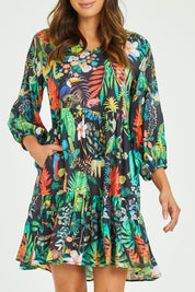Model Madeline wearing size S of the Lucile Tiered Dress in colour Midnight (Black), from the front, cropped image