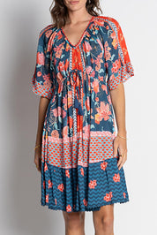 A model wearing the Mulini Dress in colour Navy, from the front, cropped image