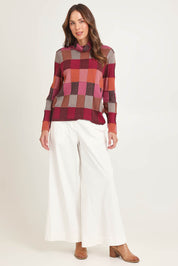 Model Madeline wearing size S of the Lindi Organic Cotton Sweater in colour Spice (Pink), from the front, showing the whole outfit