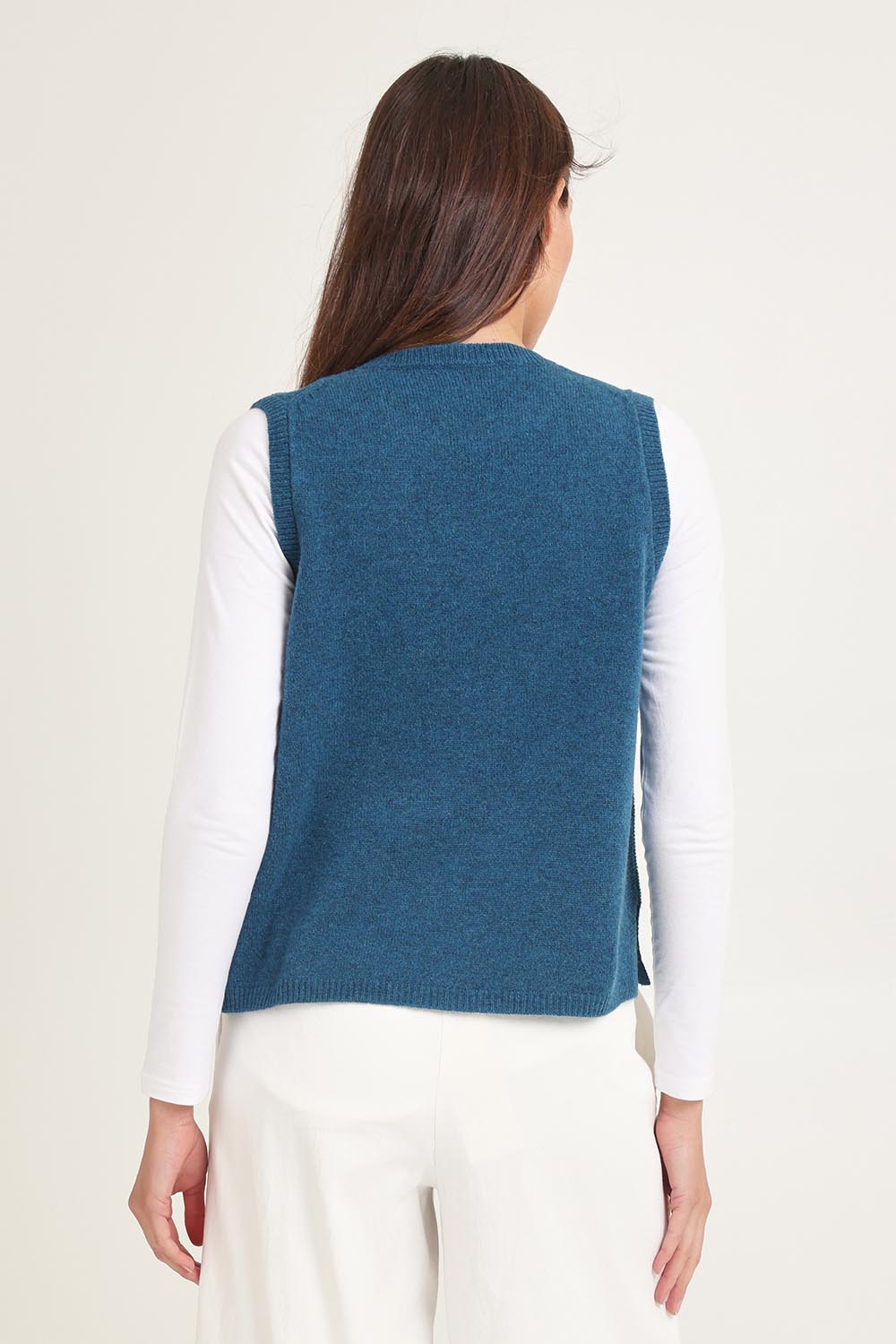 Model Madeline wearing size S of the Mitos Vest in colour Darkaqua (Green), from the back