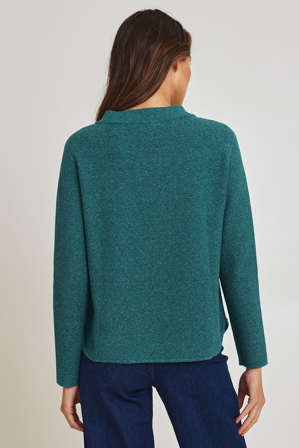 Model Madeline wearing size S of the Mosque Sweater in colour Sea (Green), from the back