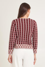 Model Madeline wearing size S of the Odette Organic Cotton Cardigan in colour Spice (Red), from the back