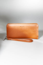 A model wearing size OneSize of the Elm Vegan Zip Around Wallet in colour Chili, from the front, showing the whole outfit