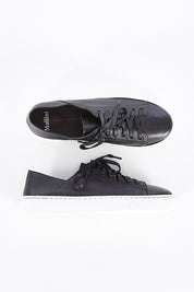 A model wearing size 37 of the Oskher Leather Sneaker in colour Blackwhite (Black), from the front, showing the whole outfit