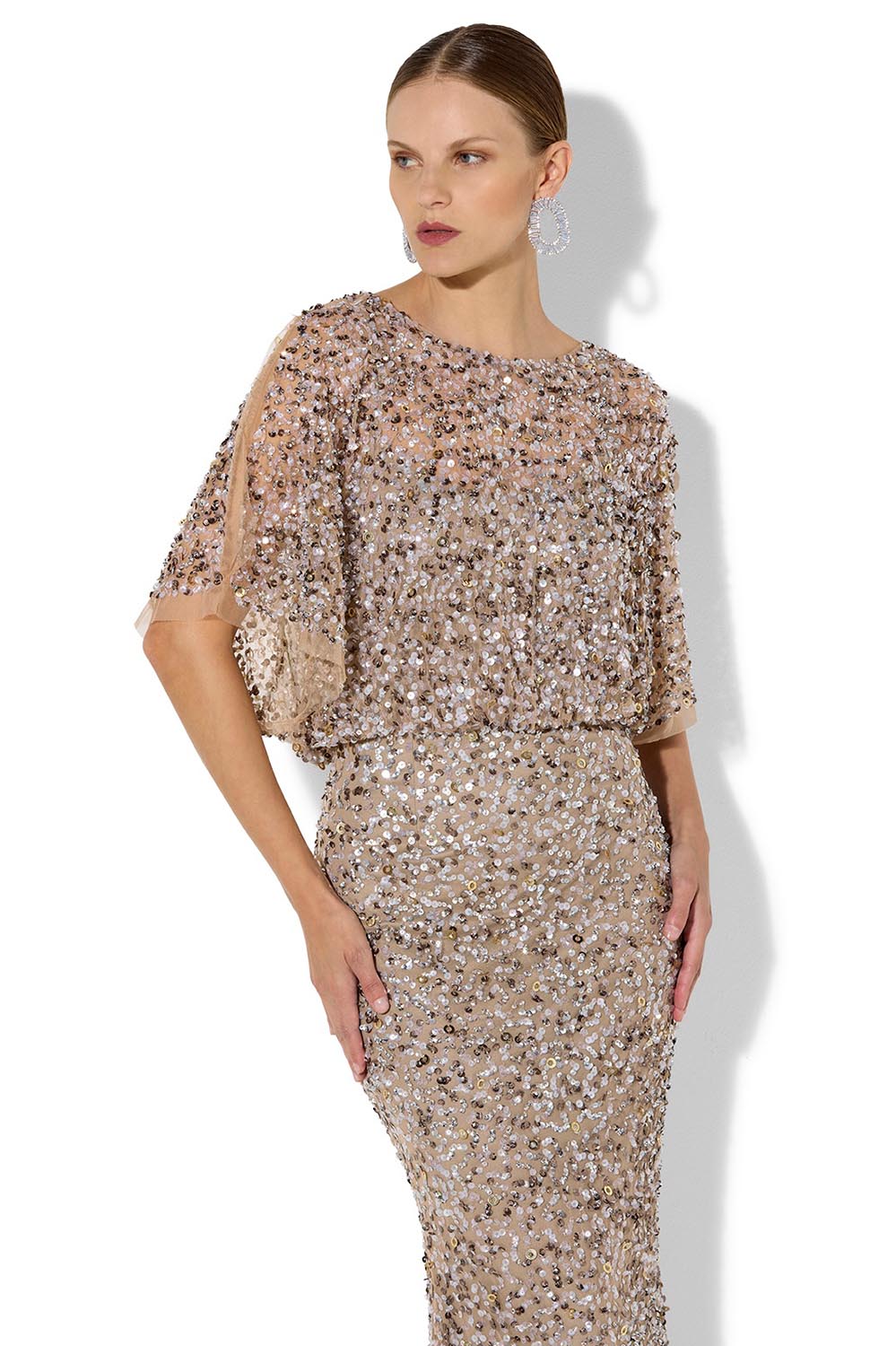 A model wearing the Mimi Hand Beaded Gown in colour Mink, from the front, cropped image