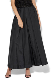 A model wearing the Lux Maxi Skirt in colour Black (Black), from the front, cropped image
