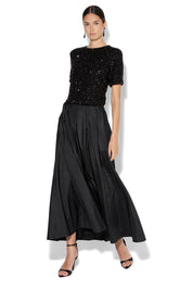 A model wearing the Lux Maxi Skirt in colour Black (Black), from the front, showing the whole outfit