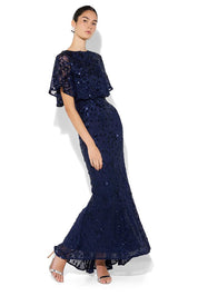A model wearing the Aria Sequin Maxi Gown in colour Navy (Blue), from the front, showing the whole outfit