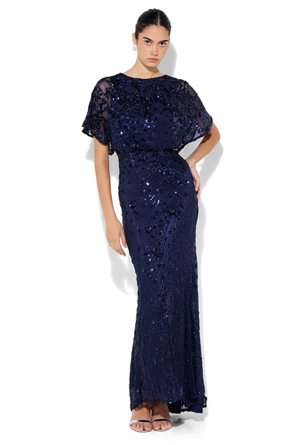 A model wearing the Aria Sequin Maxi Gown in colour Navy (Blue), from the front, showing the whole outfit