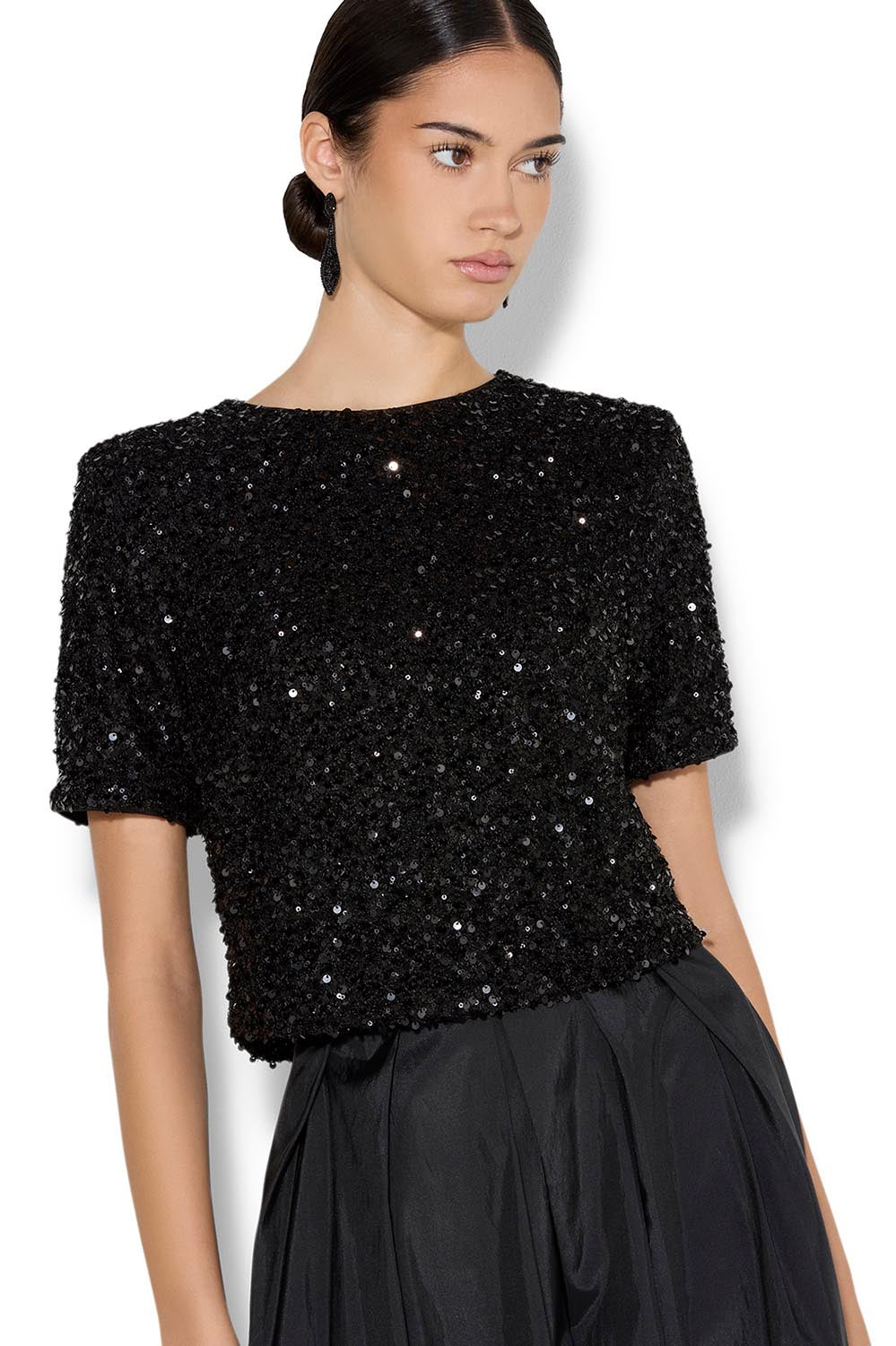 A model wearing the Ginger Sequin Top in colour Black (Black), from the front, cropped image