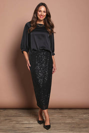 Model Madeline wearing size 10 of the Tia Blouse in colour Black (Black), from the front, showing the whole outfit