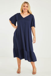 Model Katie wearing size 16 of the Mary Dress in colour Navy (Blue), from the front, showing the whole outfit