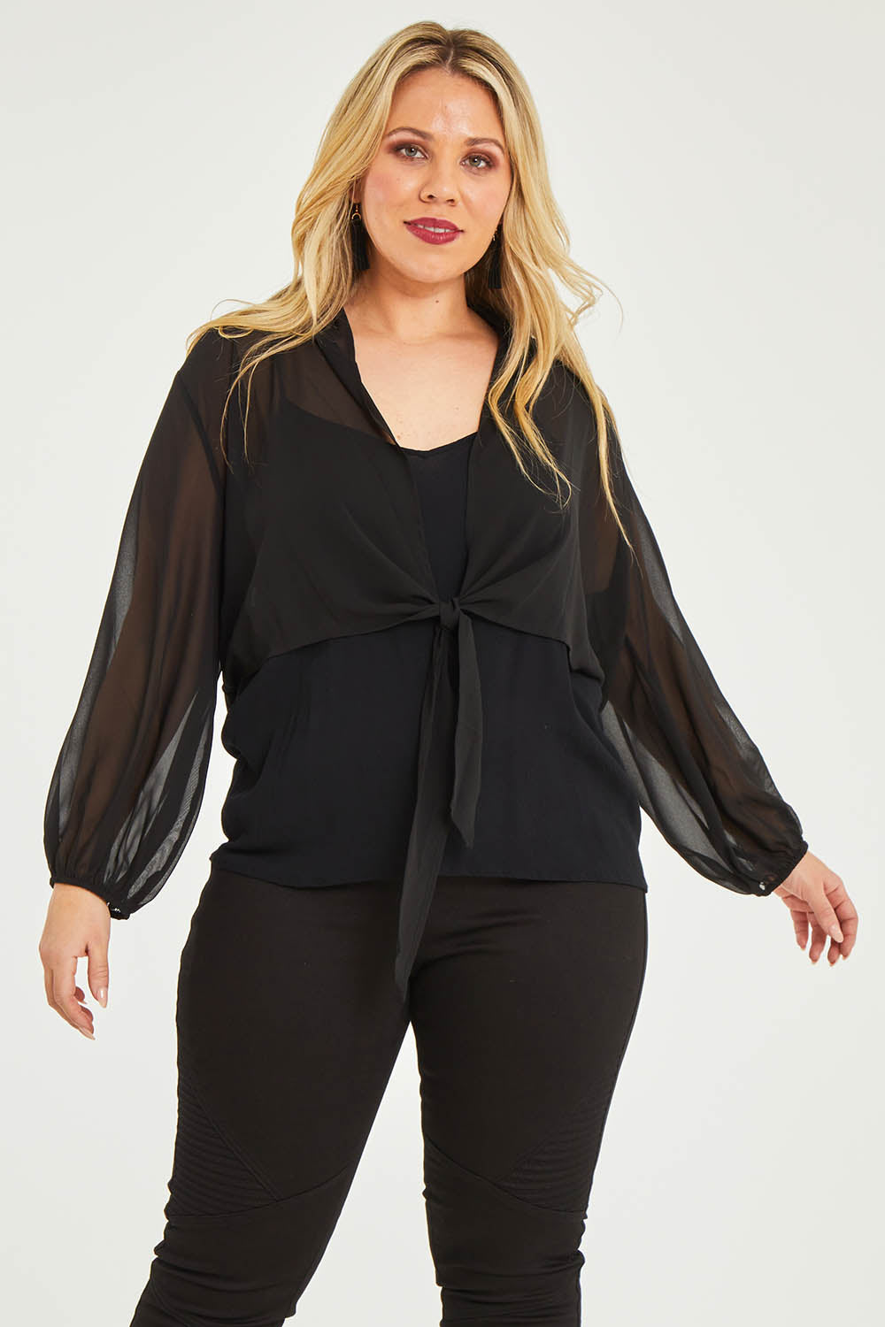 Model Katie wearing size 16 of the Penelope Shrug in colour Black (Black), from the front, cropped image