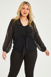 Model Katie wearing size 16 of the Penelope Shrug in colour Black (Black), from the front, cropped image