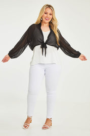 Model Katie wearing size 16 of the Penelope Shrug in colour Black (Black), from the front, showing the whole outfit