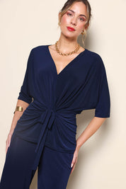 Model Maddiec wearing size 10 of the Niamh Top – Navy in colour Navy, in a cropped view
