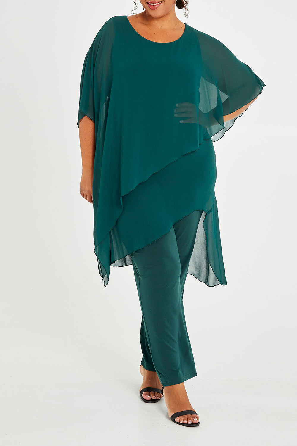 Model Alexis wearing size 18 of the Sandy Jumpsuit in colour Pine (Green), from the front, cropped image
