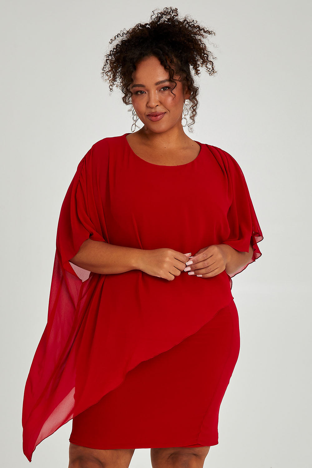 Model Alexis wearing size 16 of the Beatrice Dress in colour Red (Red), from the front, cropped image