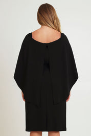 Model Chanel wearing size 16 of the Cora Dress in colour Black (Black), from the back