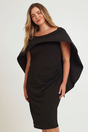 Model Chanel wearing size 16 of the Cora Dress in colour Black (Black), from the front, cropped image