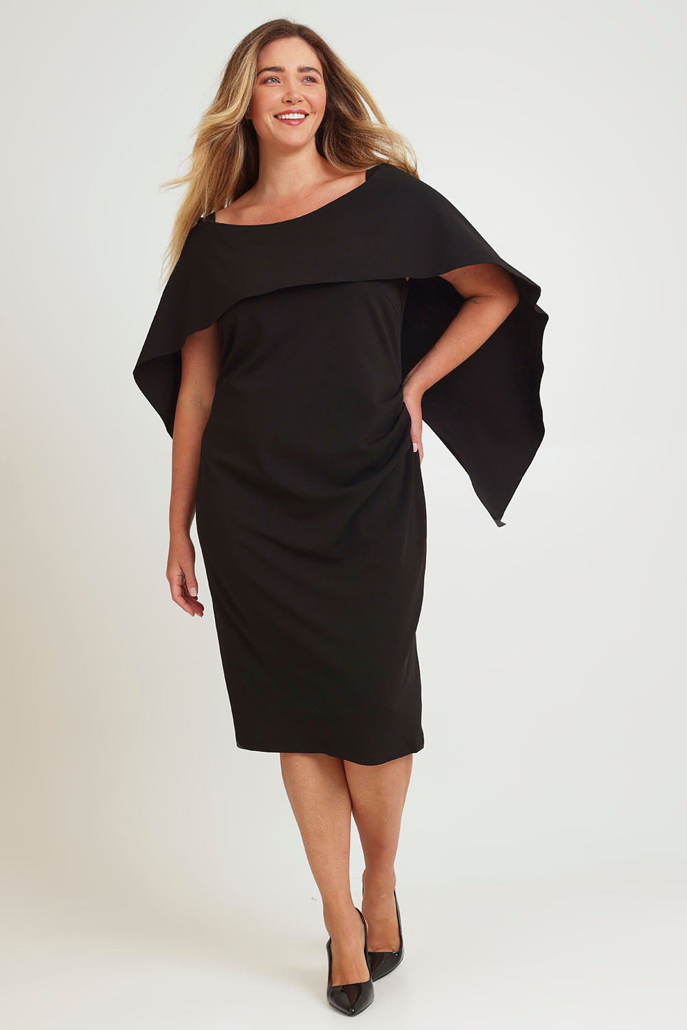 Model Chanel wearing size 16 of the Cora Dress in colour Black (Black), from the front, showing the whole outfit