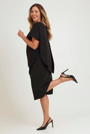 Model Chanel wearing size 16 of the Cora Dress in colour Black (Black), from the front, showing the whole outfit