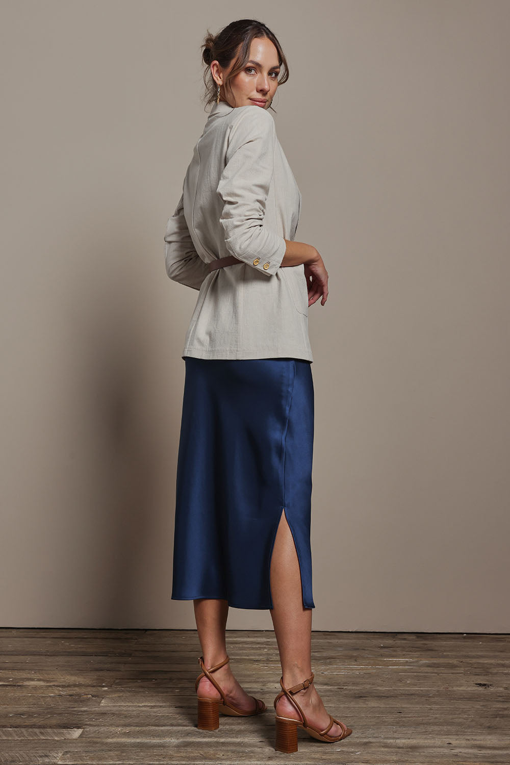 Model Madeline wearing size 10 of the Loulou Satin Skirt in colour Steelblue (Blue), from the back