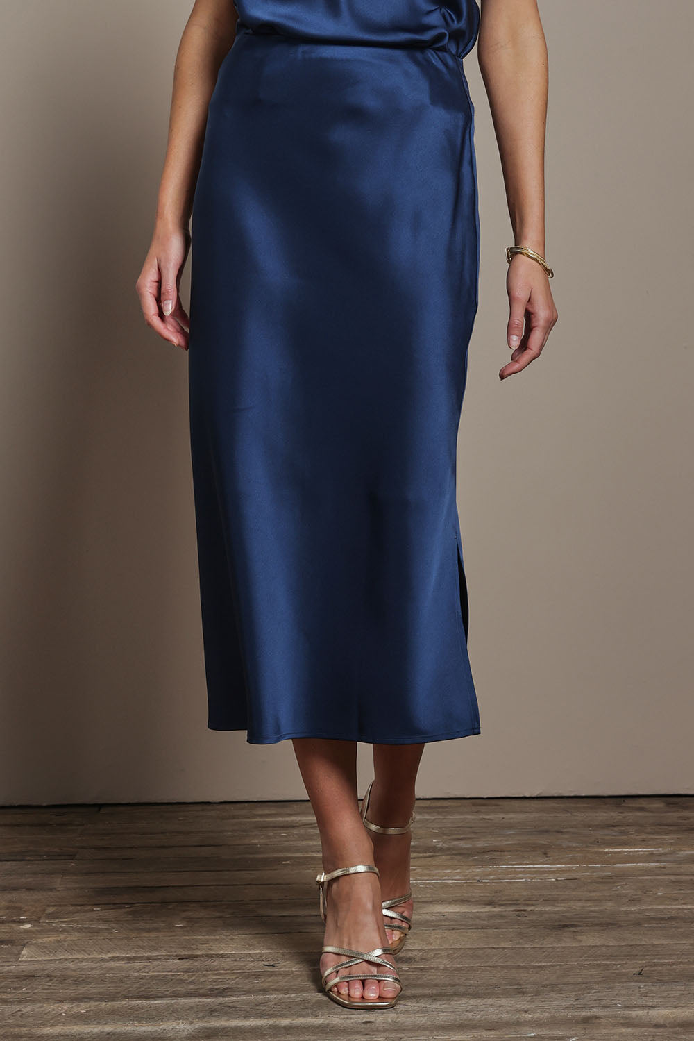 Model Madeline wearing size 10 of the Loulou Satin Skirt in colour Steelblue (Blue), from the front, cropped image