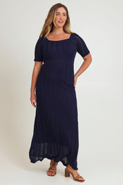 Model Chanel wearing size XL of the Ellen Knit Dress in colour Midnight (Blue), from the front, showing the whole outfit