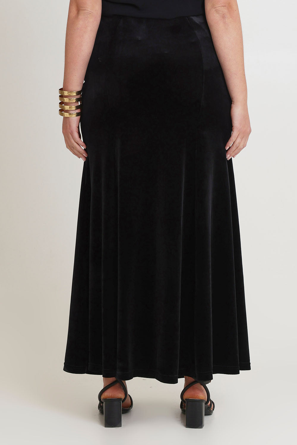 Model Chanel wearing size 16 of the Marlene Velvet Skirt in colour Black (Black), from the back