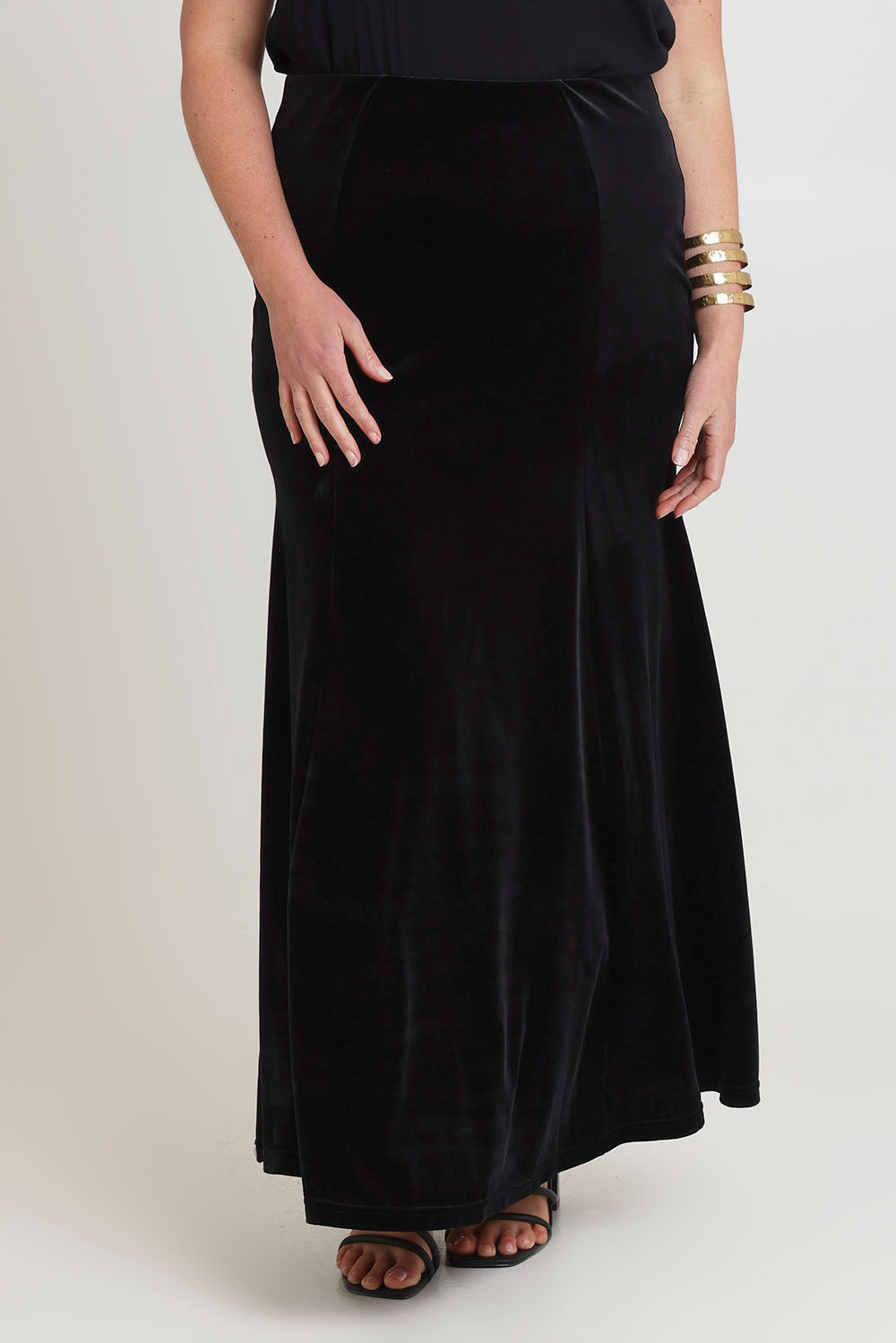 Model Chanel wearing size 16 of the Marlene Velvet Skirt in colour Black (Black), from the front, cropped image